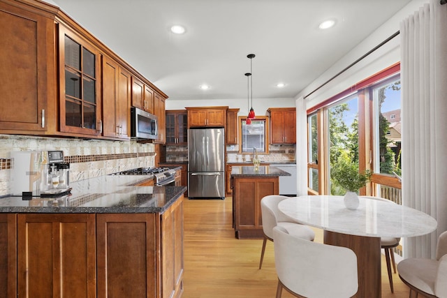 5 Bonn Pl, Weehawken, NJ 07086 - kitchen featuring stainless steel appliances, light wood finished floors, brown cabinets, decorative backsplash, and recessed lighting