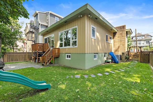 5 Bonn Pl, Weehawken, NJ 07086 - back of house with board and batten siding, a fenced backyard, stairway, a deck, and a playground