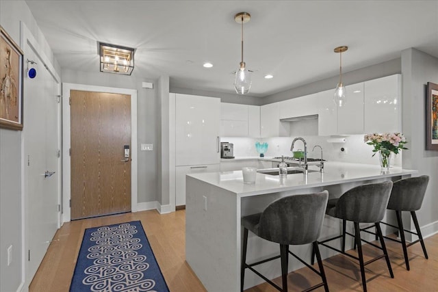9 Avenue At Port Imperial Unit 313, West New York, NJ 07093 - kitchen featuring a sink, modern cabinets, white cabinetry, a breakfast bar area, and recessed lighting