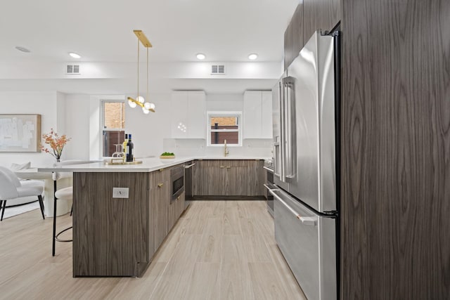 248 New York Ave Unit 1, Jersey City, NJ 07307 - kitchen with modern cabinets, a peninsula, high end fridge, a breakfast bar area, and white cabinets