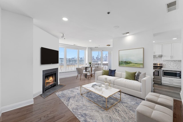 600 Harbor Blvd Unit 903, Weehawken, NJ 07086 - living area featuring dark wood-type flooring, a glass covered fireplace, baseboards, and recessed lighting