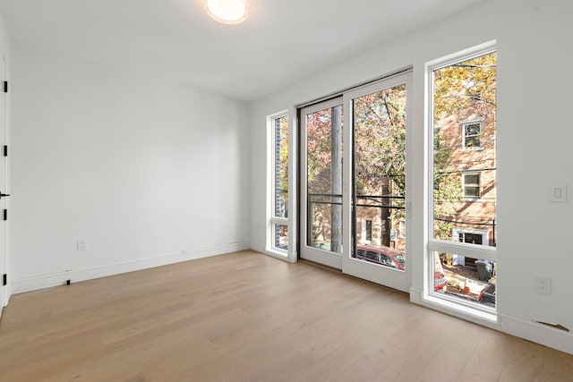 empty room with light wood-style flooring and baseboards