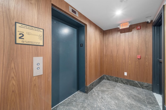 corridor featuring wood walls