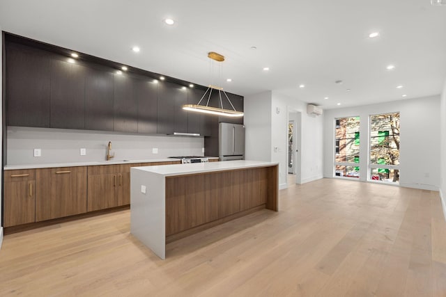 kitchen featuring a large island, modern cabinets, a sink, and freestanding refrigerator