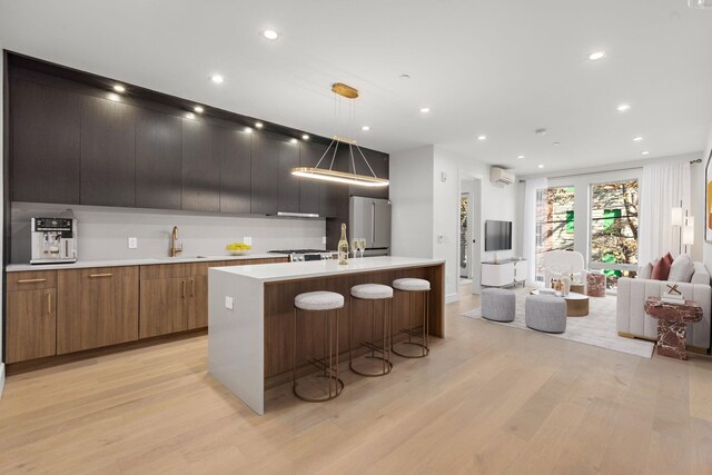 living room with light hardwood / wood-style floors and a wall mounted AC