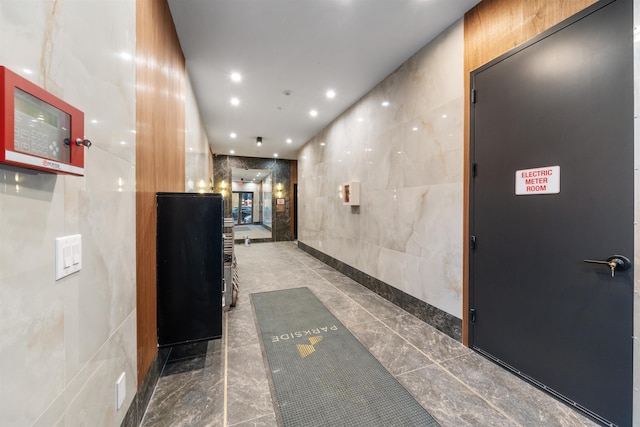 hallway with recessed lighting and tile walls