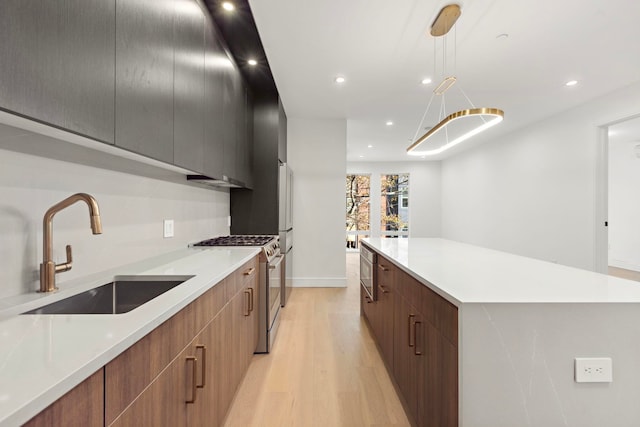 kitchen featuring gas stove, a spacious island, modern cabinets, and a sink