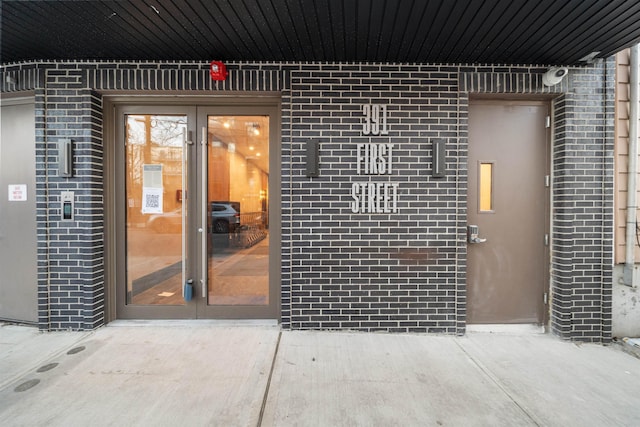 view of exterior entry featuring brick siding