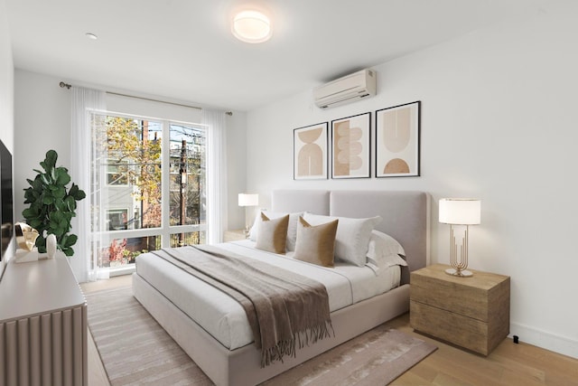 bedroom with light wood-type flooring, baseboards, and an AC wall unit