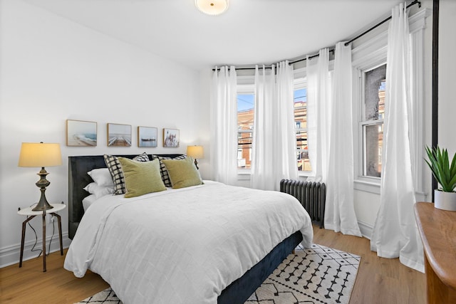 bedroom featuring light hardwood / wood-style flooring and radiator heating unit