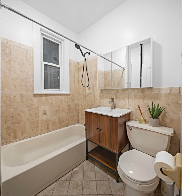 full bathroom featuring tile walls, vanity, tiled shower / bath, tile patterned floors, and toilet