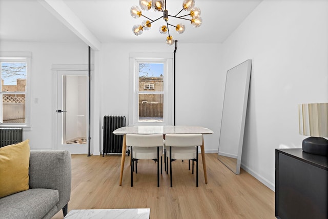 dining space featuring radiator heating unit, light hardwood / wood-style flooring, and a notable chandelier