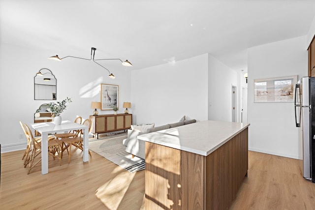 kitchen featuring stainless steel fridge, light hardwood / wood-style floors, and a center island