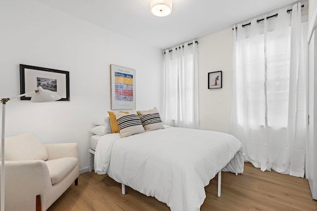 bedroom featuring hardwood / wood-style flooring and multiple windows