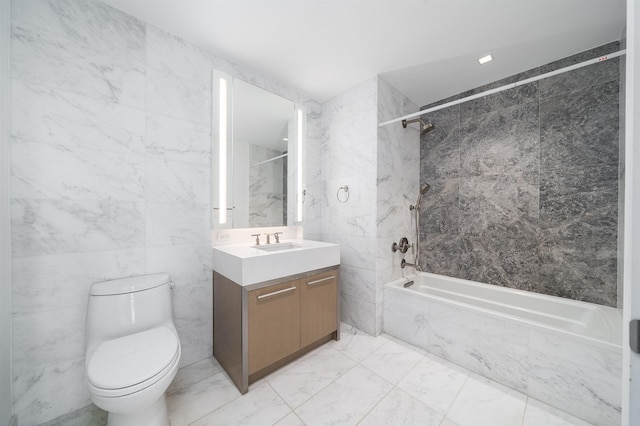 full bathroom with tile walls, vanity, toilet, and tiled shower / bath