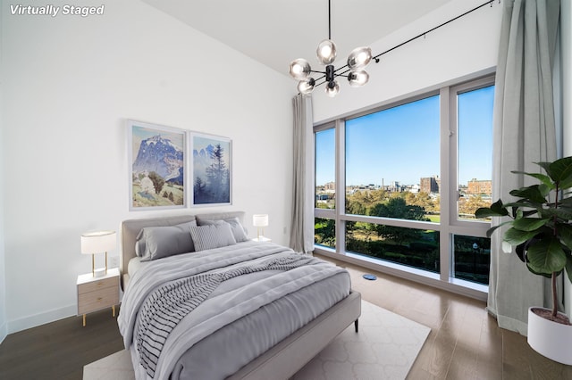 bedroom with a chandelier and dark hardwood / wood-style flooring