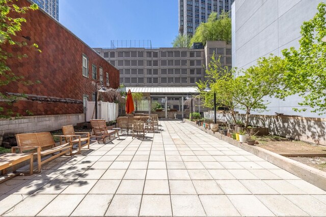 view of community with fence, a patio, and outdoor dining area