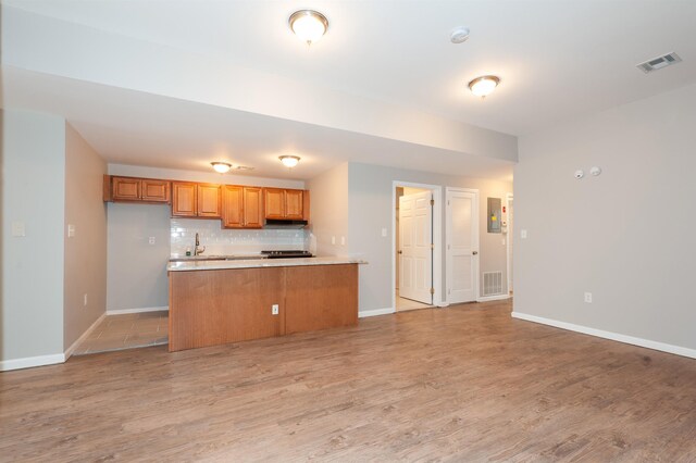 kitchen featuring light countertops, baseboards, open floor plan, tasteful backsplash, and visible vents