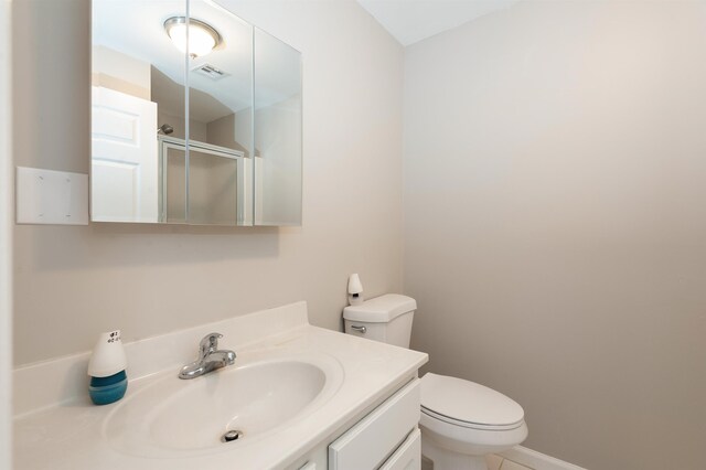 full bathroom with vanity, a shower stall, toilet, and visible vents