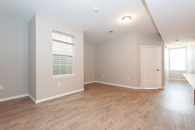 empty room featuring light wood-type flooring, baseboards, and visible vents