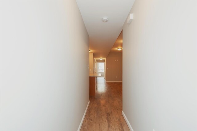 hallway featuring light wood-style floors and baseboards