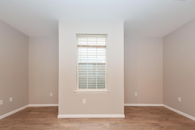 unfurnished room with baseboards and wood finished floors