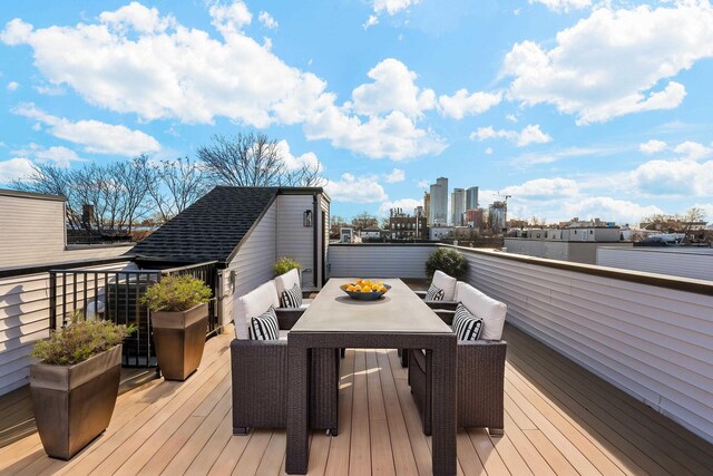 deck featuring a view of city and outdoor dining space