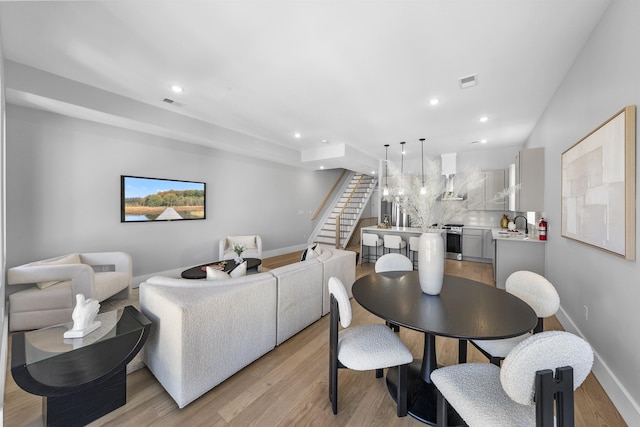 dining area with recessed lighting, visible vents, light wood finished floors, and stairs