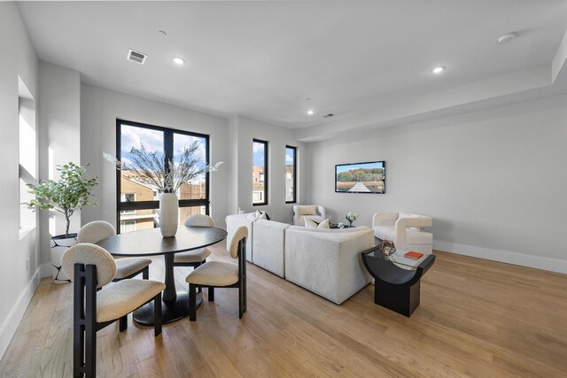 living room featuring light wood finished floors, recessed lighting, visible vents, and baseboards