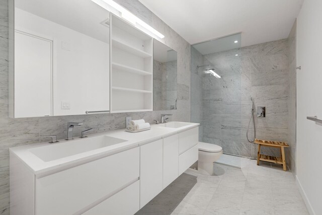 43 Provost St Unit 10O, Jersey City, NJ 07302 - bathroom with double vanity, a marble finish shower, toilet, and tile walls