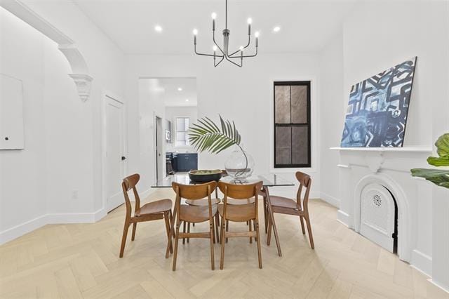 dining space featuring light parquet floors and a notable chandelier