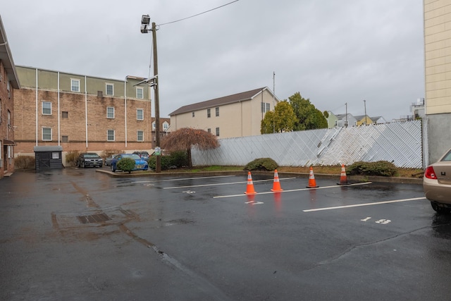 uncovered parking lot featuring fence