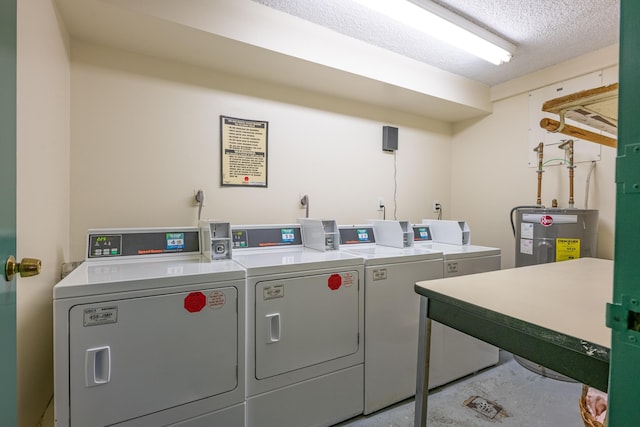 community laundry room featuring water heater, separate washer and dryer, and a textured ceiling