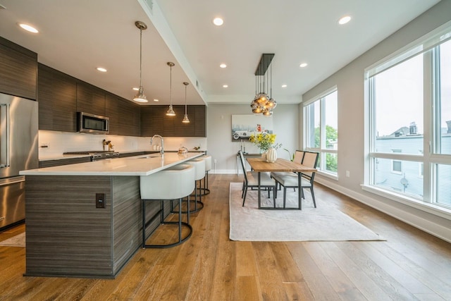 502 Palisade Ave Unit 301, Jersey City, NJ 07307 - kitchen featuring appliances with stainless steel finishes, modern cabinets, a sink, a breakfast bar area, and light countertops