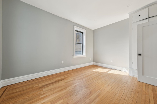 spare room featuring light wood-type flooring and baseboards