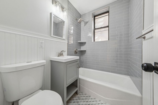 full bath featuring wainscoting, shower / tub combination, vanity, and toilet