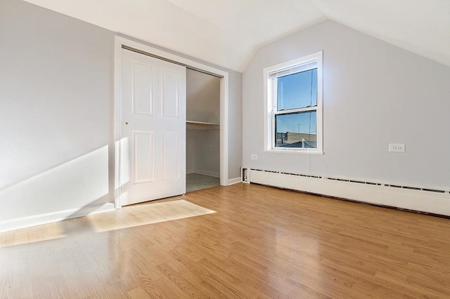 33 W 24th St, Bayonne, NJ 07002 - unfurnished bedroom with a baseboard heating unit, vaulted ceiling, wood finished floors, a closet, and baseboards