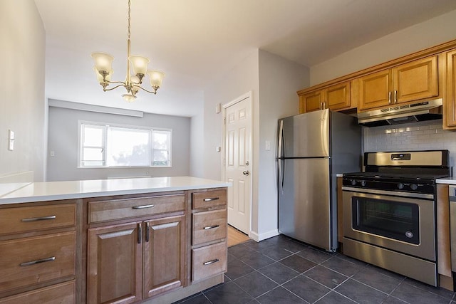 33 W 24th St, Bayonne, NJ 07002 - kitchen featuring appliances with stainless steel finishes, under cabinet range hood, brown cabinets, a chandelier, and light countertops