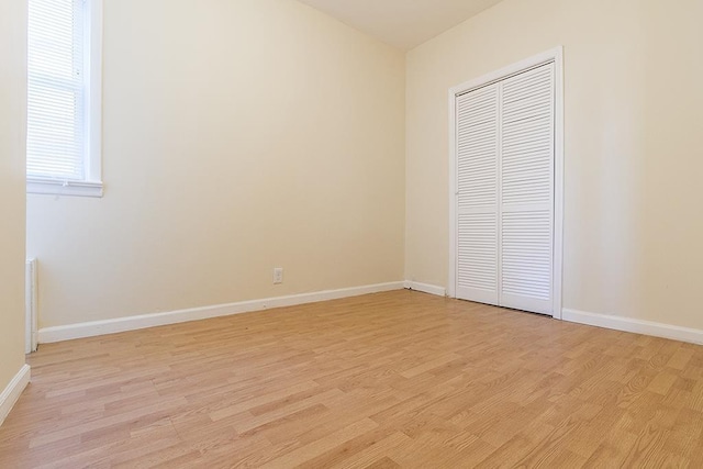 33 W 24th St, Bayonne, NJ 07002 - unfurnished bedroom featuring light wood-style floors, a closet, and baseboards