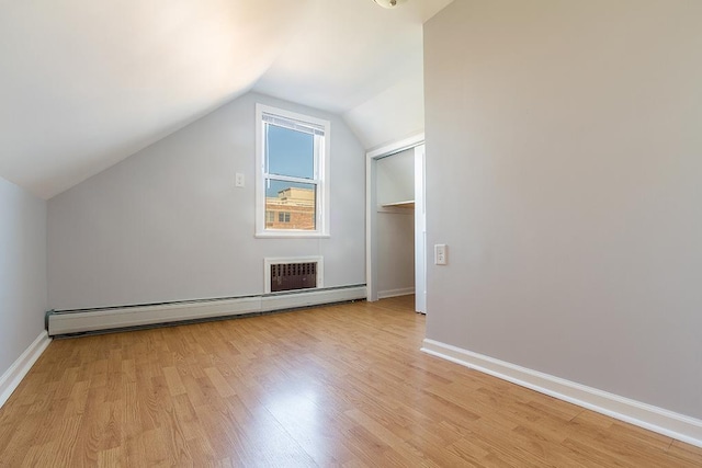 33 W 24th St, Bayonne, NJ 07002 - additional living space with baseboard heating, light wood-style flooring, vaulted ceiling, and baseboards