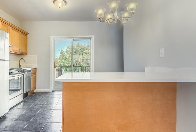 33 W 24th St, Bayonne, NJ 07002 - kitchen with appliances with stainless steel finishes, brown cabinets, a peninsula, a chandelier, and light countertops