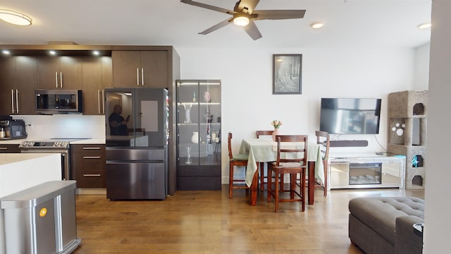 kitchen with ceiling fan, stainless steel appliances, light hardwood / wood-style floors, and dark brown cabinets