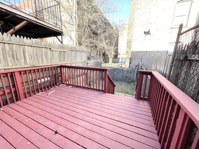 wooden terrace with a fenced backyard