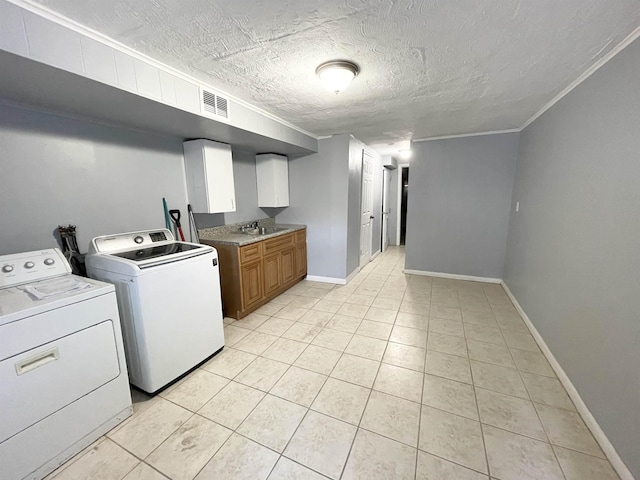 clothes washing area featuring washing machine and dryer, visible vents, baseboards, cabinet space, and crown molding