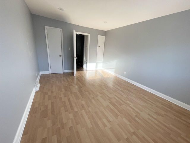 empty room with light wood-style flooring and baseboards