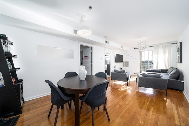 dining room with wood-type flooring and a chandelier