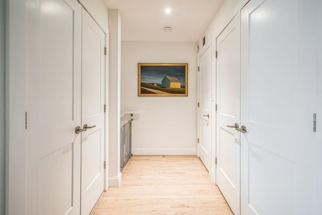 hallway with baseboards and light wood-style flooring