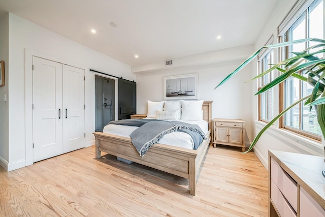 bedroom with multiple windows, light wood finished floors, and visible vents