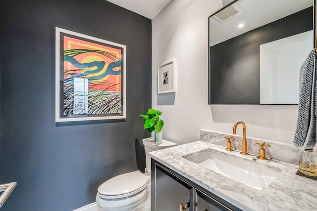 bathroom with vanity, toilet, and visible vents