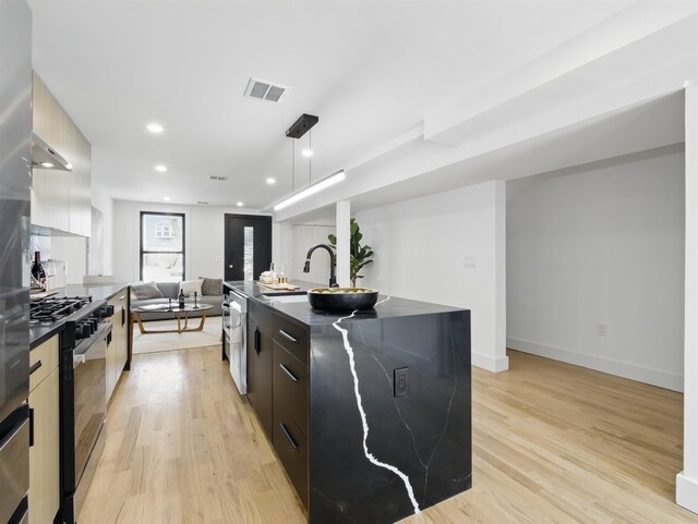 63 Jefferson Ave Unit 1, Jersey City, NJ 07307 - kitchen with modern cabinets, dark countertops, light wood-style floors, stainless steel range with gas stovetop, and open floor plan